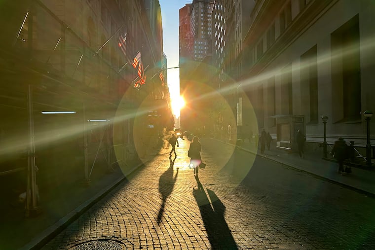 People walk on Wall Street in New York's Financial District on Wednesday, Dec. 18, 2024.