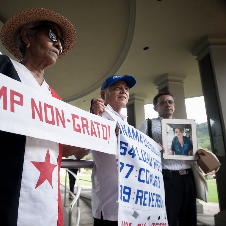 Protesters hold up signs during a demonstration marking Martyrs' Day, a national day of mourning to honor the 21 Panamanians who were killed during the January 1964 anti-American riots over sovereignty of the Panama Canal Zone, in Panama City on Thursday.