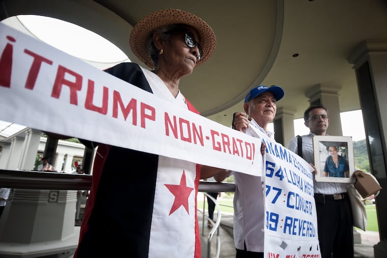 Protesters hold up signs during a demonstration marking Martyrs' Day, a national day of mourning to honor the 21 Panamanians who were killed during the January 1964 anti-American riots over sovereignty of the Panama Canal Zone, in Panama City on Thursday.