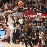 Erik Reynolds, center, of St. Joseph's goes up for a shot between Des Watson, left, and Sheldon Edwards of  Loyola Chicago during the 2nd half  on Jan. 11, 2025.