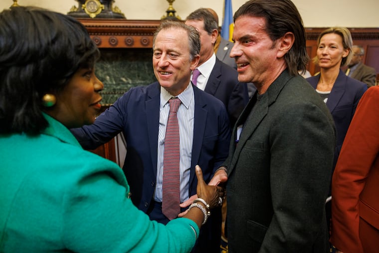 Philadelphia Mayor Cherelle L. Parker shakes hands with Sixers owner David Adelman (right), who stands next to fellow team owner Josh Harris.