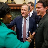 Philadelphia Mayor Cherelle L. Parker shakes hands with Sixers owner David Adelman (right), who stands next to fellow team owner Josh Harris.