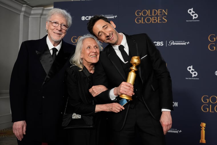 Elliot Brody, from left, Sylvia Plachy, and Adrien Brody, winner of the award for best performance by a male actor in a motion picture drama for "The Brutalist," at the 82nd Golden Globes on Sunday, Jan. 5, 2025, at the Beverly Hilton in Beverly Hills. (AP Photo/Chris Pizzello)