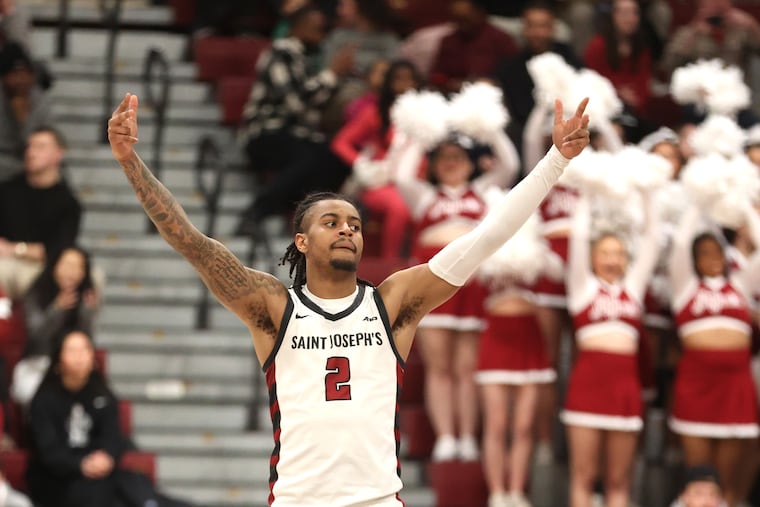 St. Joe's guard Erik Reynolds raises his arms after a three-pointer that aided in a 94-57 defeat of Loyola-Chicago on Saturday at Hagan Arena.