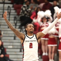 St. Joe's guard Erik Reynolds raises his arms after a three-pointer that aided in a 94-57 defeat of Loyola-Chicago on Saturday at Hagan Arena.