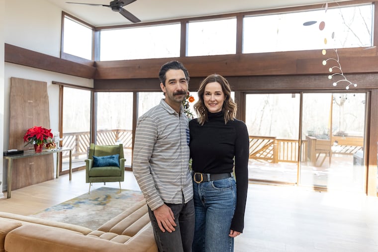 Sam and Amanda Kirk pose for a portrait inside their home in Newtown Square on Thursday, Dec. 26, 2024. The couple completed extensive renovations on the home to accentuate its original midcentury modern design.