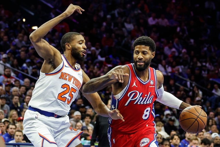 Sixers forward Paul George drives against the Knicks' Mikal Bridges during a game at the Wells Fargo Center in Philadelphia, Tuesday, November 12, 2024.