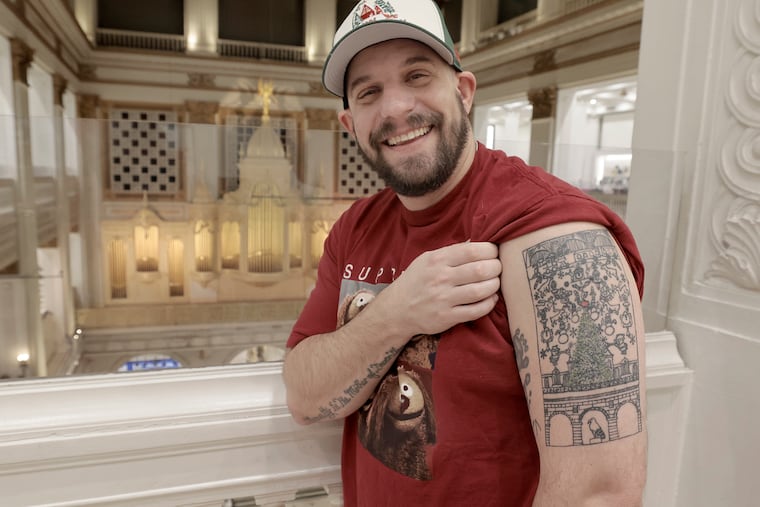 Lance Sugarman displays his tattoo of the Macy’s Christmas Light Show at Macy's in Center City on Friday.