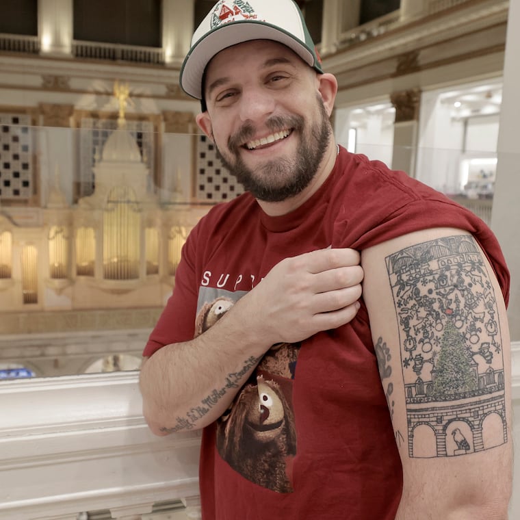 Lance Sugarman displays his tattoo of the Macy’s Christmas Light Show at Macy's in Center City on Friday.