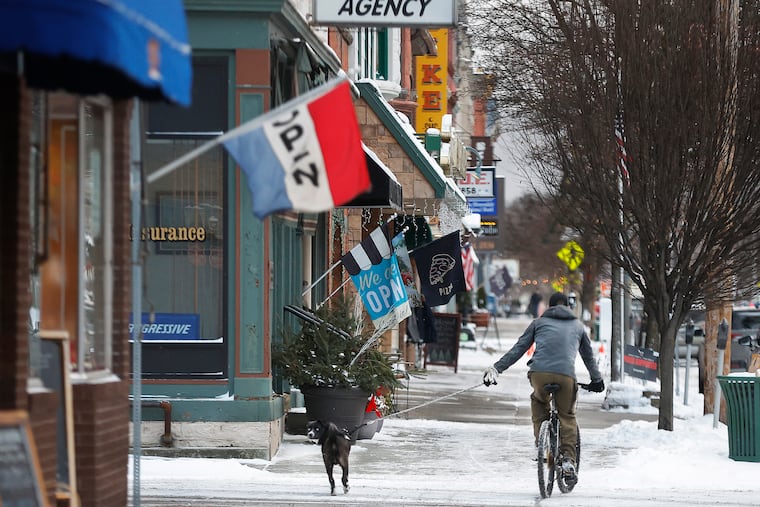 A man rides his bike and walks his dog on Main Street Dec. 21 2024, in Honesdale.