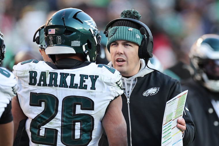 Eagles offensive coordinator Kellen Moore talks to Philadelphia Eagles running back Saquon Barkley.