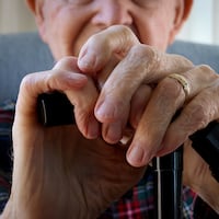 Charles Malloy, 99, rests his hands on his cane as he poses for a portrait at his home in West Chester on Wednesday, April 24, 2024.