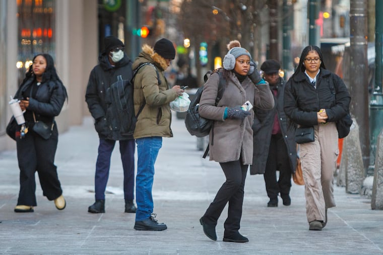 Pedestrians bundled up for the cold on Tuesday, when winds gusted past 35 mph. After a touch of snow, the winds are due to go on break.