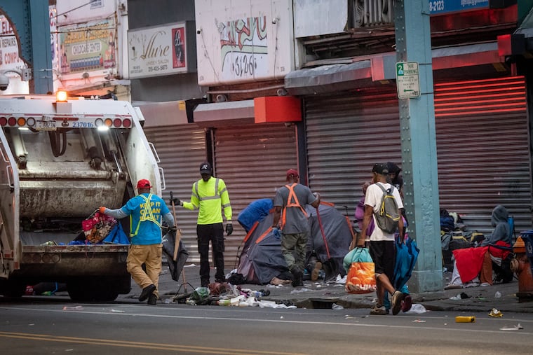 Sanitation workers clean up trash during the relocation of people with addiction who had been living in a street encampment on Kensington Avenue in Philadelphia in May 2024. Harm reduction advocates say that they feel City Hall has attempted on several occasions this year to curtail their work with people in addiction, including during May's encampment clearing.