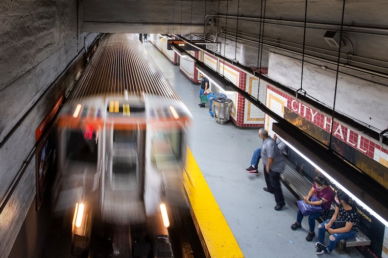 Travelers wait for the train at the South City Hall station.