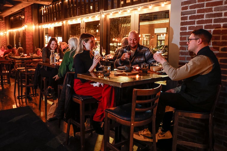 Jesse Andreozzi (center), known as Philly's "Mr. Zero Proof" and a zero-proof menu consultant, talks with friends at Bar Hygge on Fairmount Street.