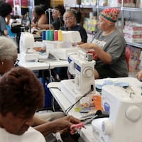 Pan African Sisterhood Health Initiative (P.A.S.H.I.) volunteer Gail Hoffman (right) makes pads with other volunteers at the Ujima Friends Peace Center in Philadelphia on Wednesday, June 12, 2024.