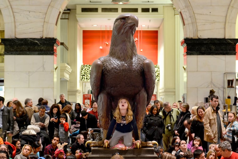 An 8-year-old waits under the John Wanamaker Eagle for the start of Macy's "Christmas Pageant of Lights" in 2019.