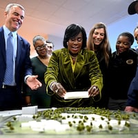 Mayor Cherelle L. Parker places a new block on the scale model of the Riverview Wellness Village Wednesday, Jan. 8, 2025 during the unveiling of Philadelphia’s new city-operated drug treatment facility. At left is Managing Director Adam Thiel and Councilmember Michael Driscoll is at right.